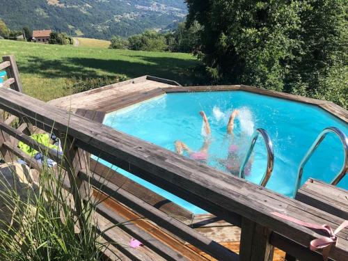 un groupe de personnes dans une piscine dans l'établissement Chalet les Champerons - Entre Lacs et Montagne, à Marthod