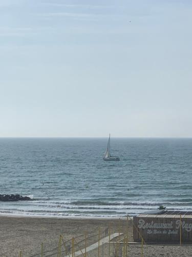 a boat in the ocean with a sail boat at Très bel appartement front de mer -4 personnes- in Palavas-les-Flots