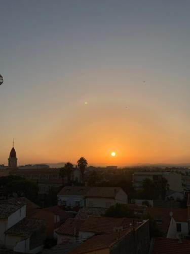 a sunset over the roofs of a city at Très bel appartement front de mer -4 personnes- in Palavas-les-Flots