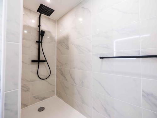 La salle de bains blanche est pourvue d'une douche avec un pommeau de douche. dans l'établissement Magnifique T2 Hypercentre Arles, à Arles