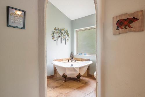 a bathroom with a white tub and a window at Worth the Wake in Branson