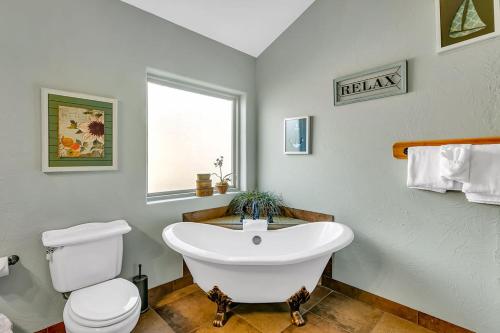 a bathroom with a white tub and a toilet at Worth the Wake in Branson