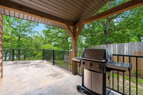 a grill on a patio with a fence at Worth the Wake in Branson