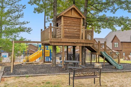 a playground with a tree house and a slide at Worth the Wake in Branson