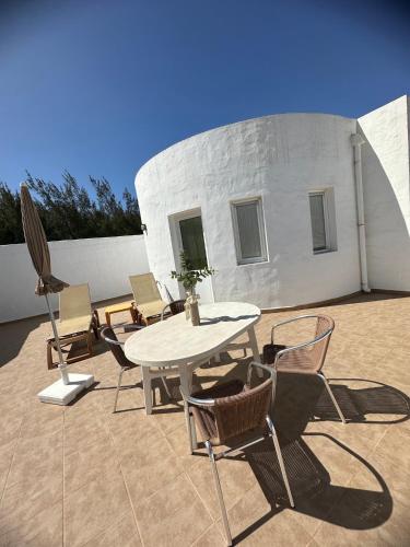 a patio with a table and chairs and a building at Casa Adriana in Costa Calma