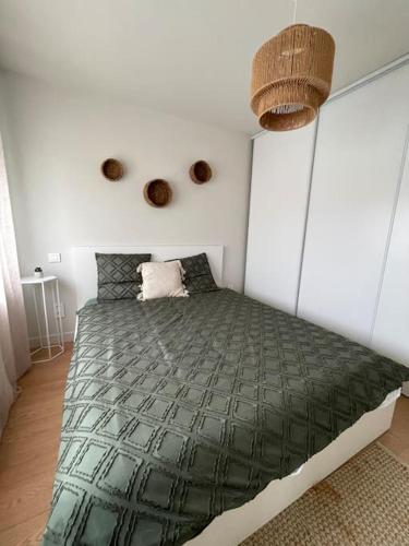 une chambre avec un lit avec une couette verte dans l'établissement Opale plage, à Dunkerque