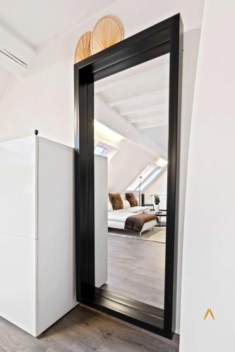 a mirror in a room with a bed in the background at Charming 1BR Loft in Ville-Haute, Luxembourg in Luxembourg