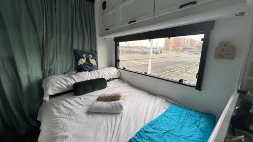 a small bed in a room with a window at Cool Wheels on the Waterfront in Liverpool