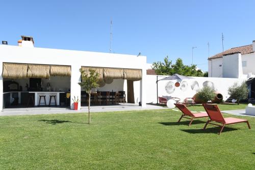 a yard with two chairs and a house at Torga42 in Ponte de Sor