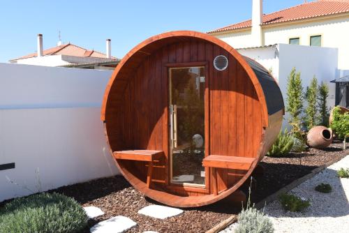 a wooden circle shaped sauna in a garden at Torga42 in Ponte de Sor