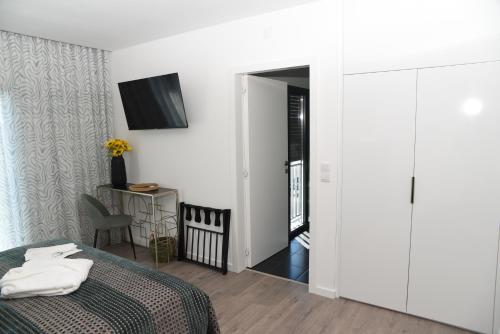 a bedroom with a bed and a tv on a wall at Torga42 in Ponte de Sor