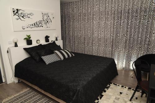 a bedroom with a bed with a black comforter at Torga42 in Ponte de Sor