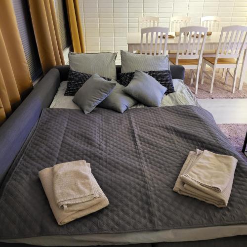 a bed with two pillows and two towels on it at Tilava uudistettu perheasunto in Rovaniemi