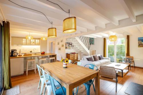 Il comprend une cuisine et un salon avec une table. dans l'établissement Maison familiale 11 couchages, proche de La Palue, à Crozon