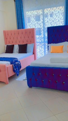 Ένα ή περισσότερα κρεβάτια σε δωμάτιο στο Staycation One and Two Bedroom apartment Mombasa