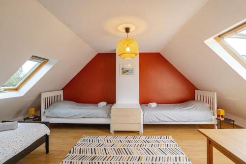 two beds in a attic room with red walls at Maison familiale 11 couchages, proche de La Palue in Crozon