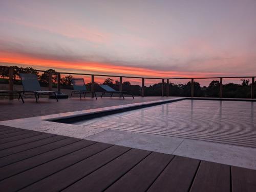 a pool on the roof of a building with a sunset at Chez Lilie in Le Sel
