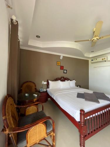 a bedroom with a bed and a table and chairs at Banyan Tree Samudra in Kovalam