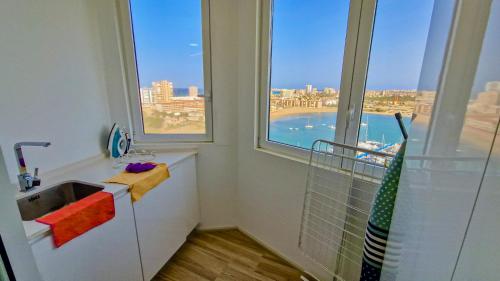 une salle de bain avec un lavabo et une grande fenêtre dans l'établissement Atico de lujo vistas dos mares, à La Manga del Mar Meno