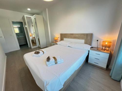 Un dormitorio con una cama grande con dos zapatos. en PUSHE Playa Granada Beach & Golf 8, en Motril