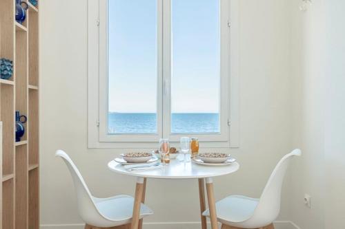 une table à manger blanche avec des chaises et une fenêtre dans l'établissement 