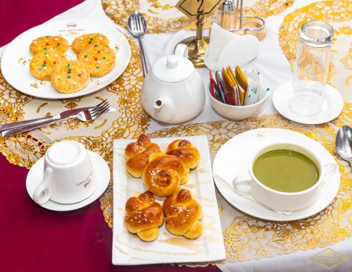 einen Tisch mit Teller Donuts und einer Tasse Kaffee in der Unterkunft Hotel New Riviera bukavu in Bukavu