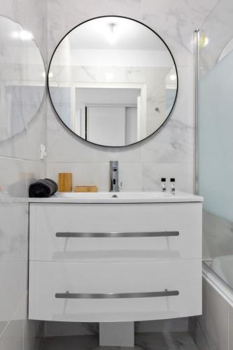 une salle de bain avec un lavabo blanc et un miroir dans l'établissement Le Prince - Quiet - Parking - Hypercenter - AC, à Cannes