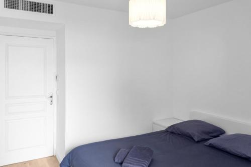 - une chambre blanche avec un lit et des oreillers violets dans l'établissement Le Prince - Quiet - Parking - Hypercenter - AC, à Cannes