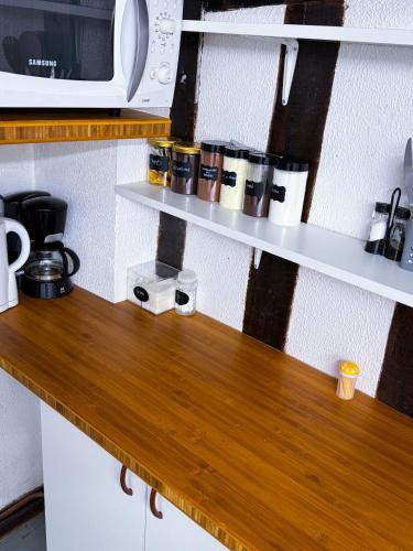 un comptoir en bois avec un four micro-ondes sur une étagère dans l'établissement Le Cocon Urbain Central, à Chartres
