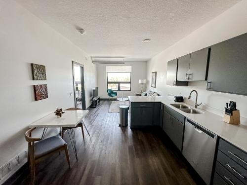 a kitchen with a sink and a table in it at Sleepover 1BD 1BA Des Moines Apartments in Des Moines
