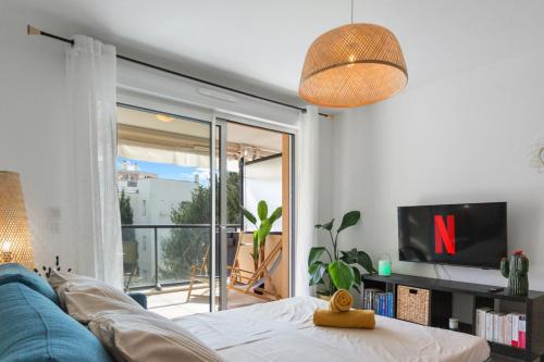 un salon avec un canapé bleu et une télévision dans l'établissement L'Eden - Quiet - Parking - WIFI - Beach, à Antibes