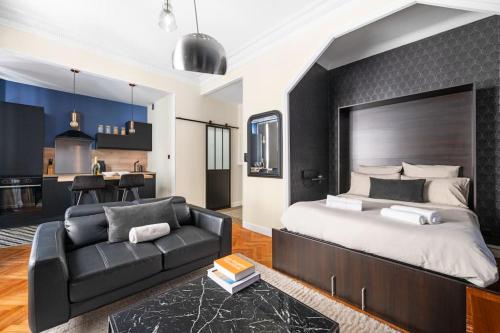 - une chambre avec un grand lit et un canapé noir dans l'établissement Raffinement en pleine ville, à Nice