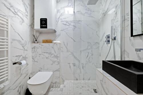 une salle de bain blanche avec des toilettes et un lavabo dans l'établissement Raffinement en pleine ville, à Nice