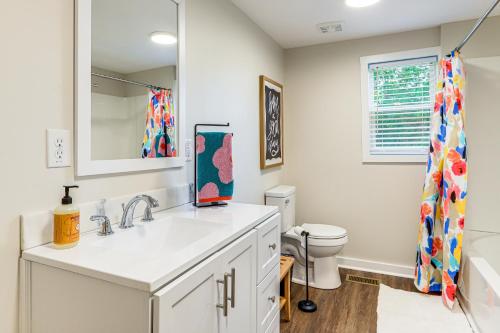 un bagno bianco con lavandino e WC di Downtown Heflin Cottage with Deck and Fire Pit! a Heflin