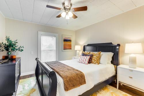 una camera da letto con un letto e un ventilatore a soffitto di Downtown Heflin Cottage with Deck and Fire Pit! a Heflin