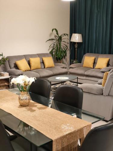 a living room with couches and a table and chairs at Modern Space in Prime Location in Dubai