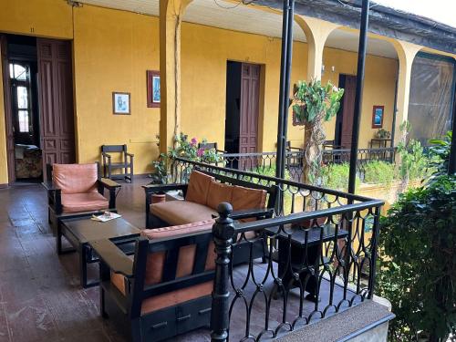 a porch with a couch and chairs on a balcony at Hotel Spring in Guatemala