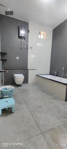 a bathroom with a toilet and a tv on the wall at Archana palace hampi in Hampi
