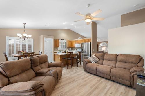 a living room with two couches and a kitchen at Sunny Home with Backyard Oasis in San Tan Valley! in Queen Creek