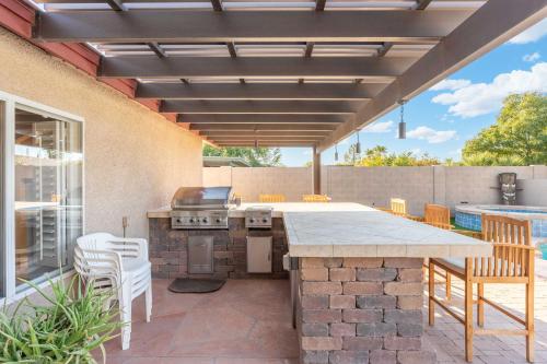 a patio with a table and chairs and a grill at Sunny Home with Backyard Oasis in San Tan Valley! in Queen Creek