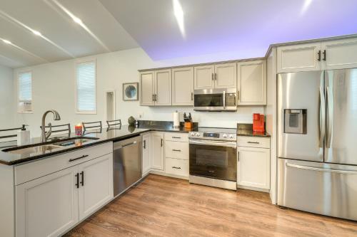 a kitchen with white cabinets and stainless steel appliances at Near Kanawha River Unique Renovated Home with Yard! in Glen Ferris