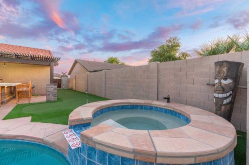 a swimming pool in a yard with a fence and a house at Sunny Home with Backyard Oasis in San Tan Valley! in Queen Creek