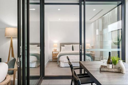 莫宁顿LUXE - Location, Style, Space in the heart of town的一间卧室，配有一张床、一张桌子和几把椅子