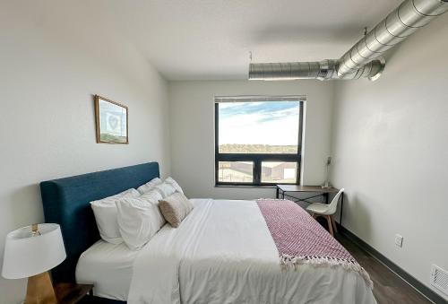 a white bedroom with a bed and a window at Sleepover 1BD 1BA Des Moines Apartments in Des Moines