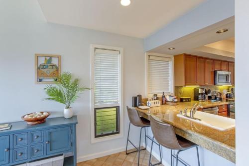 a kitchen with blue cabinets and a counter with bar stools at Gorgeous Kapalua Home with Views in Kahana
