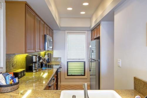 a kitchen with a sink and a refrigerator at Gorgeous Kapalua Home with Views in Kahana