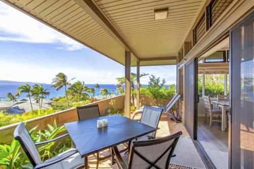 a patio with a table and chairs on a balcony at Gorgeous Kapalua Home with Views in Kahana