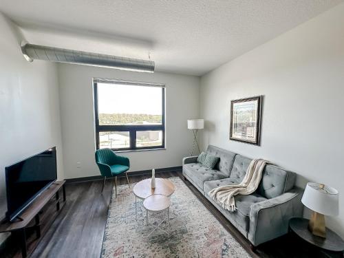 a living room with a couch and a tv at Sleepover 1BD 1BA Des Moines Apartments in Des Moines