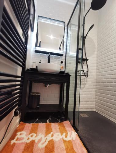 une salle de bain avec un lavabo et un miroir dans l'établissement Au Coin Fleuri, à La Bernerie-en-Retz