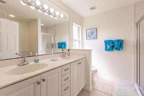 Un baño con lavabo, espejo e inodoro. en 1395 Marco Island, en Marco Island